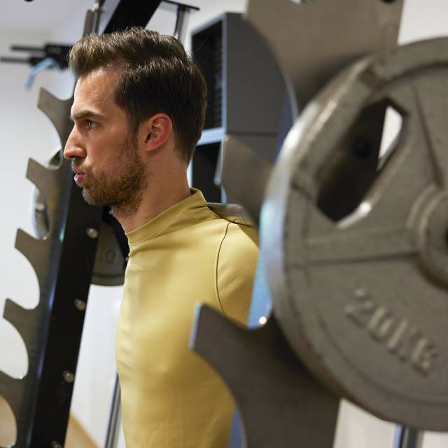 Mann beim Gewichtheben im Fitnessraum im Sauerland Stern Hotel