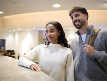 Gäste und Concierge mit Gepäck im Foyer des Sauerland Stern Hotel Willingen