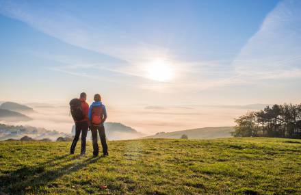 Wanderer genießen den Sonnenuntergang auf dem Rothaarsteig