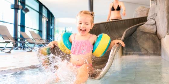 Kind mit Schwimmflügeln auf Rutsche im Lagunen-Erlebnisbad Willingen