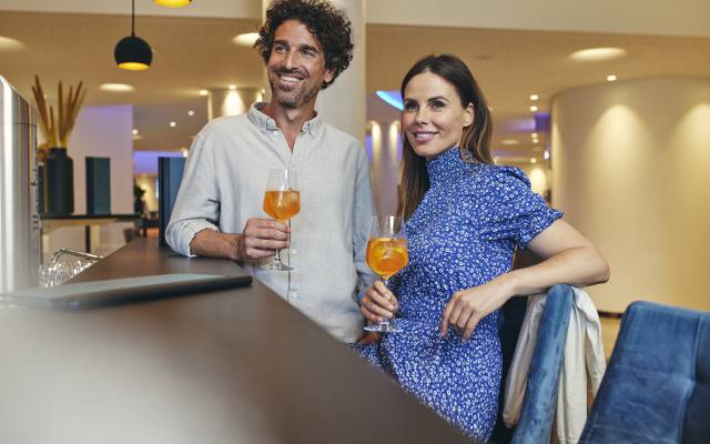 Paar mit Cocktails an der Bar im Sauerland Stern Hotel Willingen
