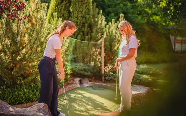 Zwei Frauen beim Minigolf spielen