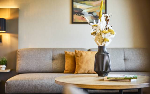 Tisch mit Blumenvase und Büchern im Sauerland Stern Hotel Willingen