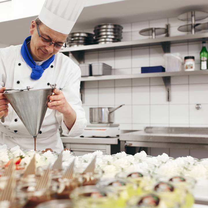 Koch in der Küche des Sauerland Stern Hotel Willingen bereitet Nachspeise vor