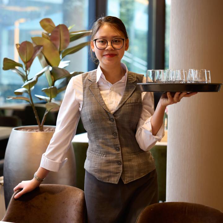 Kellnerin mit Gläsern auf Tablett im Sauerland Stern Hotel Willingen