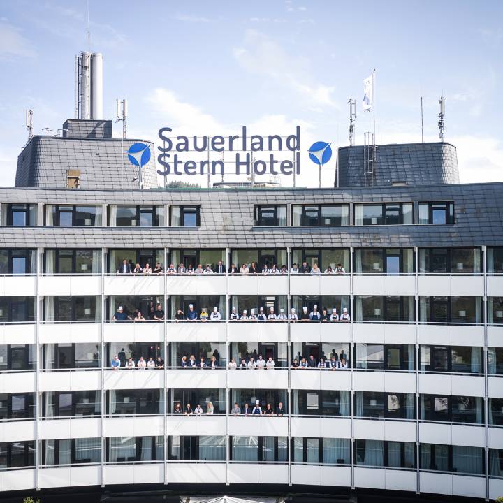 Außenaufnahme der Mitarbeiter des Sauerland Stern Hotel Willingen auf Balkons 
