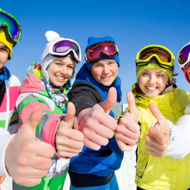 Freunde im Schnee bunte Skikleidung
